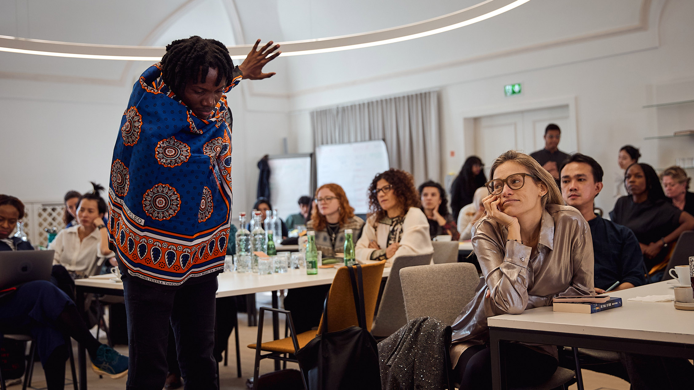 Samwel Japhet performs a dance in front of a group of Salzburg Global Fellows in Fellows Hall of Schloss Leopoldskron