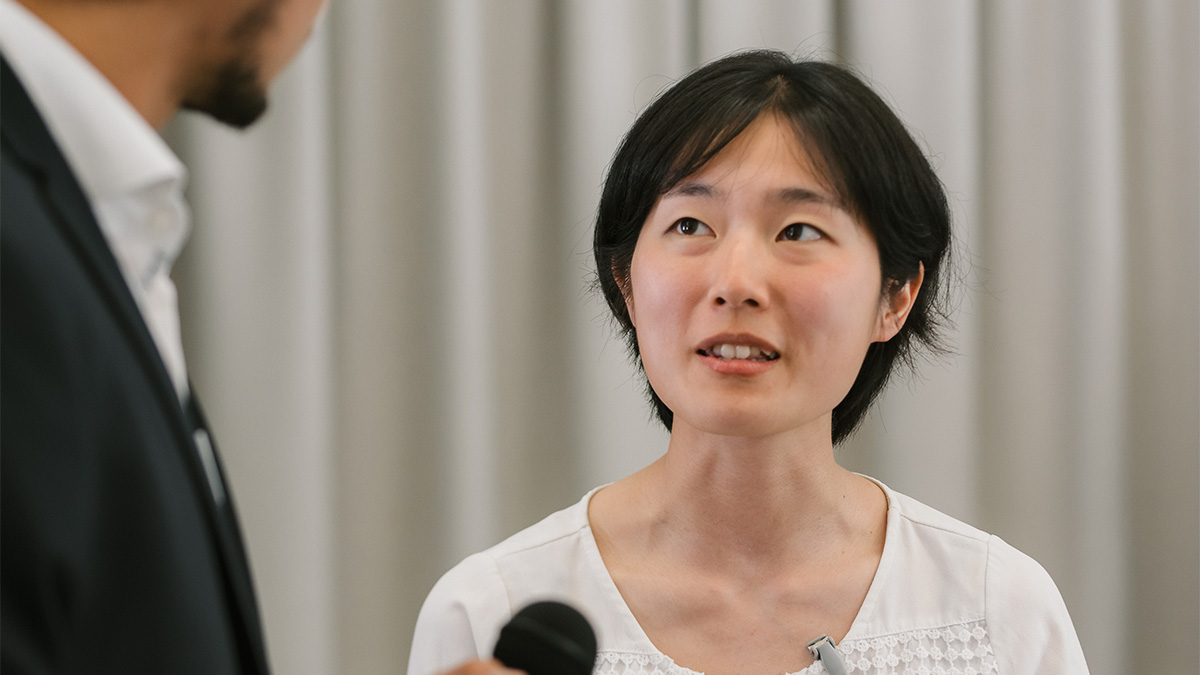 a woman with short dark hair looking to the left while talking