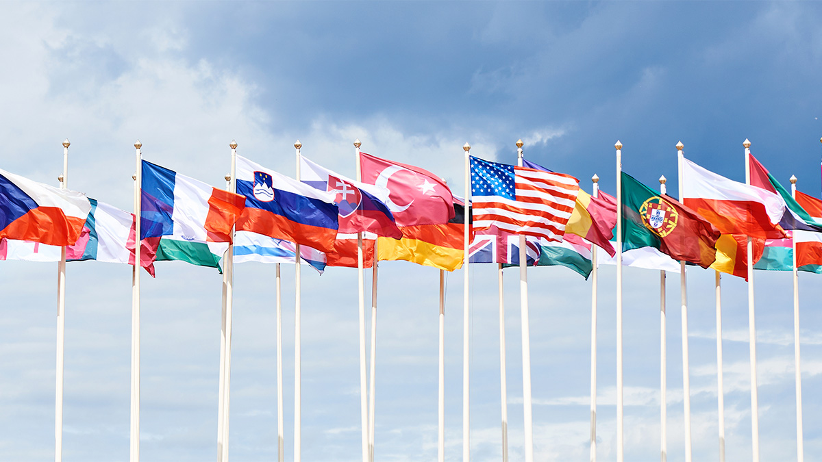 A line of flags from many different countries waving in the wind
